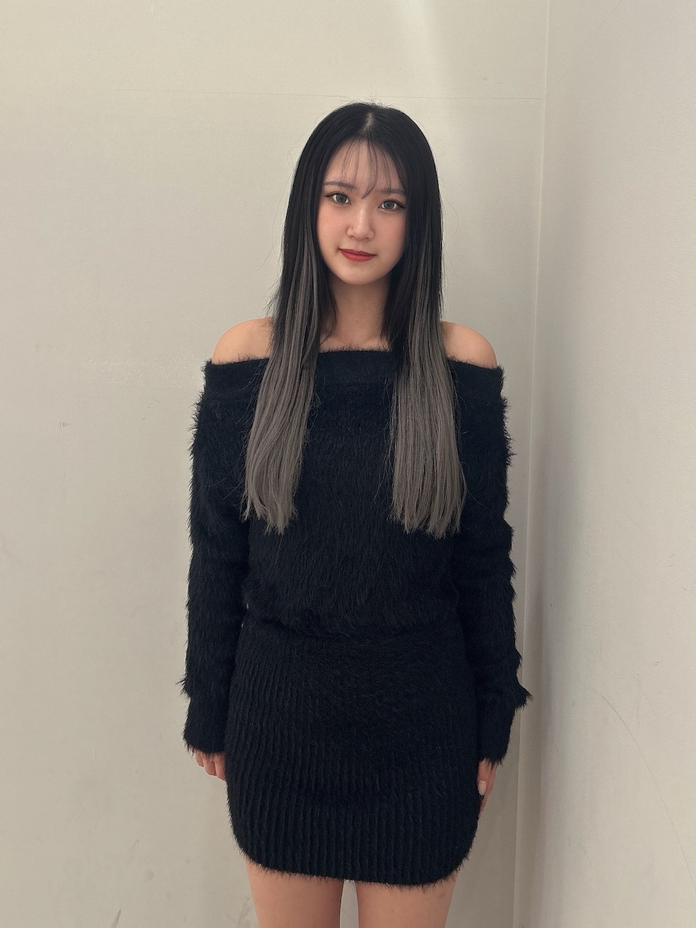 ブラック系のダウンジャケット/コート、ブラック系のワンピース、ブラック系のブーツを着用したレディースの秋コーディネートの4枚目の写真