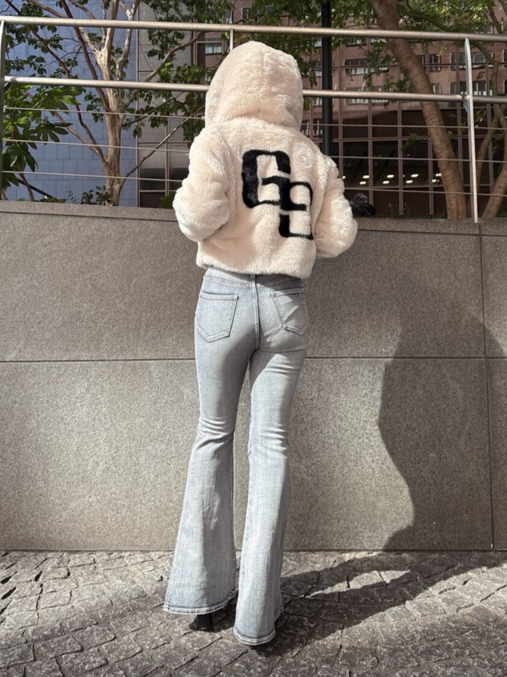 ブラック系のブーツ、ホワイト系のニット/セーター、ホワイト系のブルゾンを着用したレディースの秋コーディネートの3枚目の写真