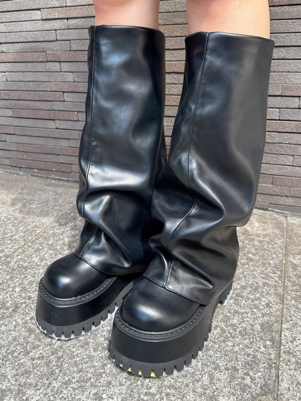 ブルー系のデニムスカート、ブラック系のブーツ、ブラック系のパーカーを着用したレディースの秋コーディネートの9枚目の写真