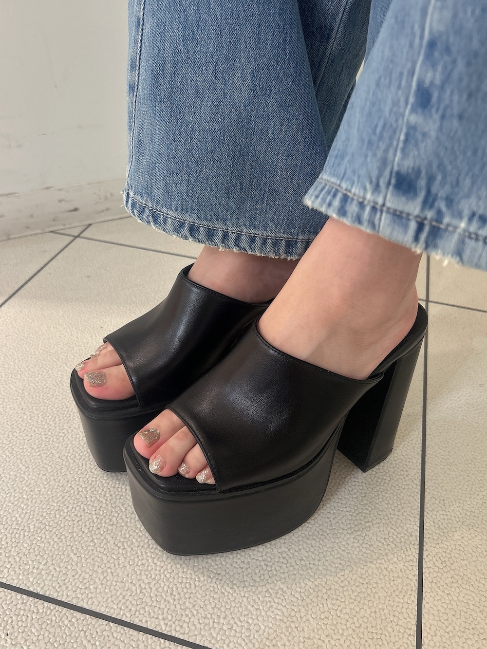 ブルー系のニット/セーター、ホワイト系のシャツ/ブラウス、ブルー系のデニムパンツを着用したレディースの夏コーディネートの9枚目の写真