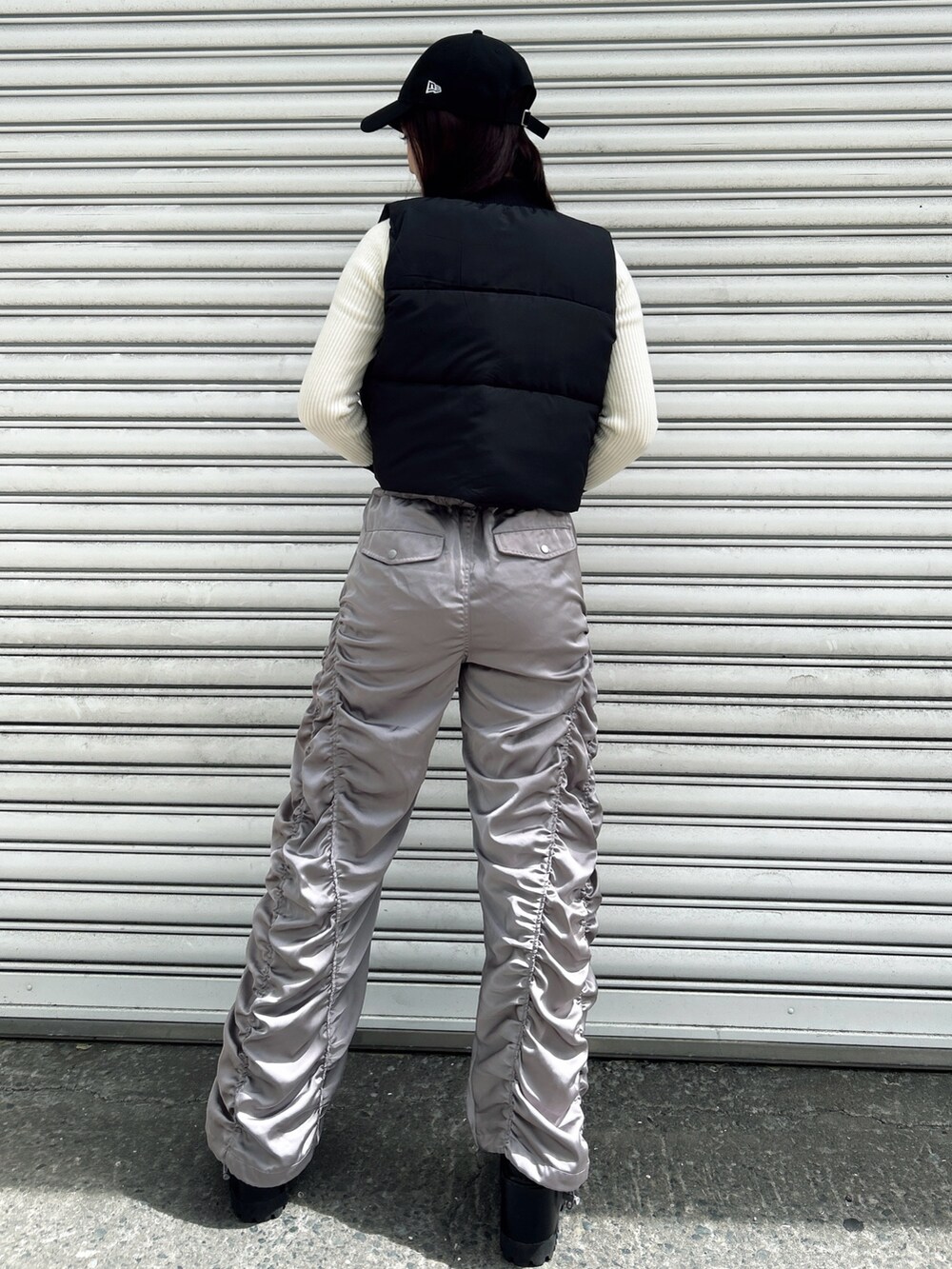 グレー系のその他パンツ、ブラック系のベスト、ホワイト系のニット/セーターを着用したレディースの秋コーディネートの2枚目の写真