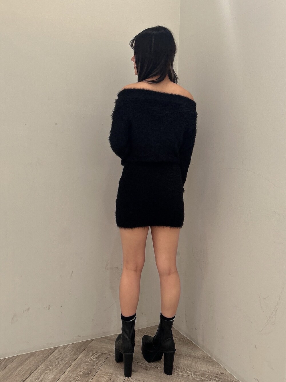 ブラック系のダウンジャケット/コート、ブラック系のワンピース、ブラック系のブーツを着用したレディースの秋コーディネートの7枚目の写真