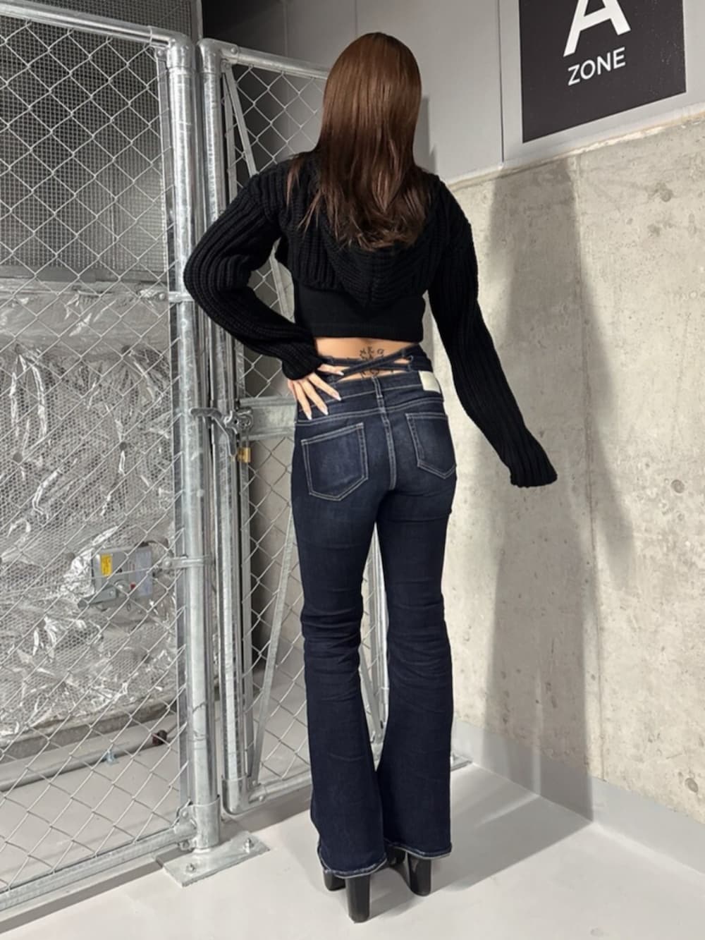 ブラック系のブーツ、ブラック系のニット/セーター、ブルー系のデニムパンツを着用したレディースの冬コーディネートの3枚目の写真