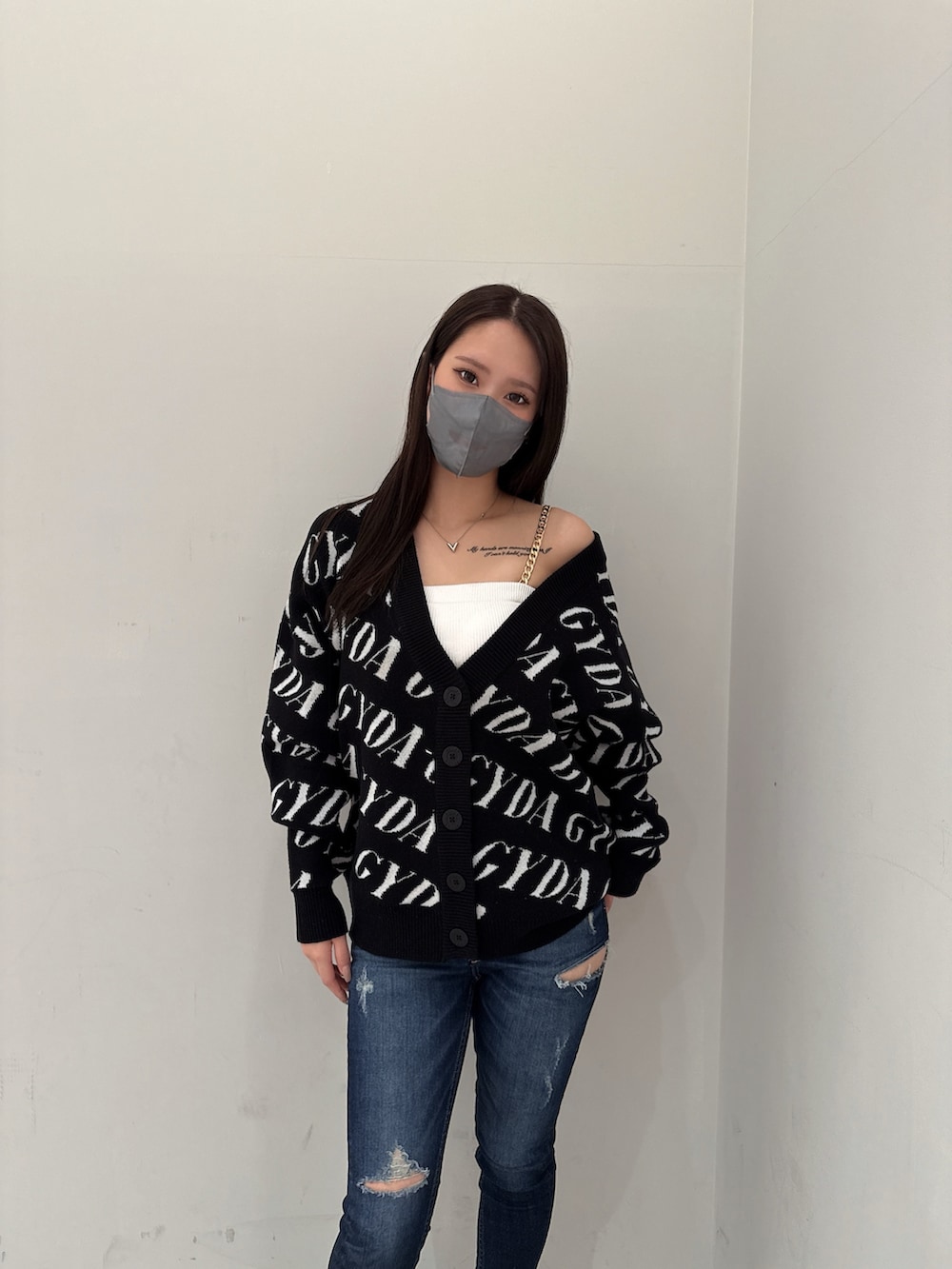 ブラック系のカーディガン/ボレロ、ホワイト系のキャミソール、ブルー系のデニムパンツを着用したレディースの春コーディネートの4枚目の写真