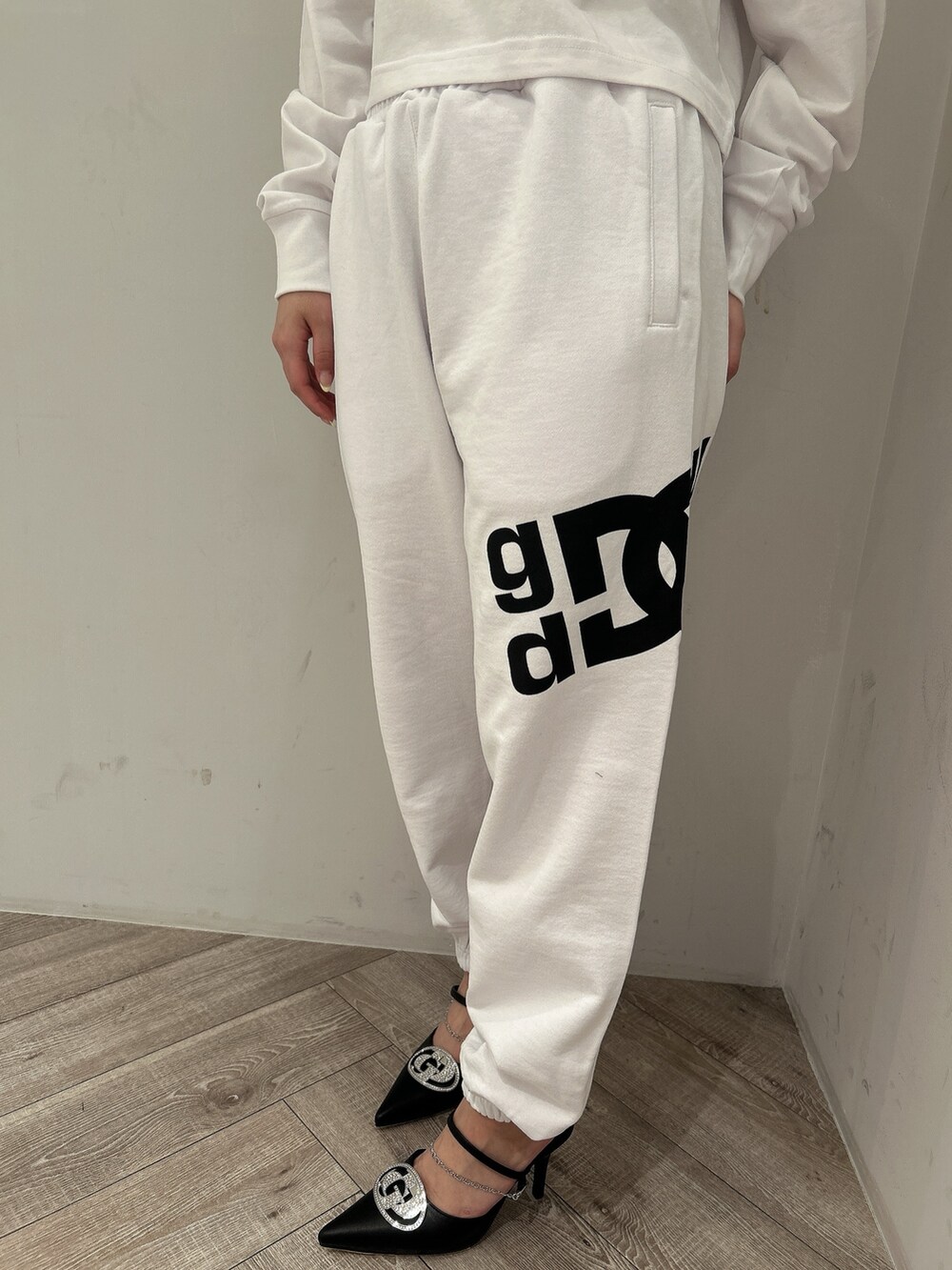 ホワイト系のTシャツ/カットソー、ホワイト系のスウェットパンツ、ブラック系のパンプスを着用したレディースの春コーディネートの6枚目の写真