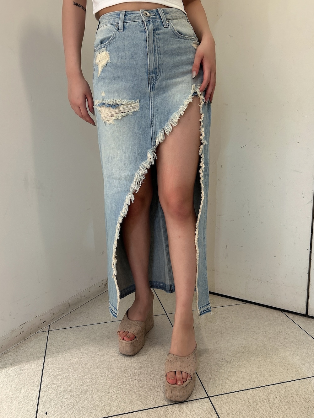 ホワイト系のTシャツ/カットソー、ブルー系のデニムスカート、ホワイト系のサンダルを着用したレディースの春コーディネートの8枚目の写真