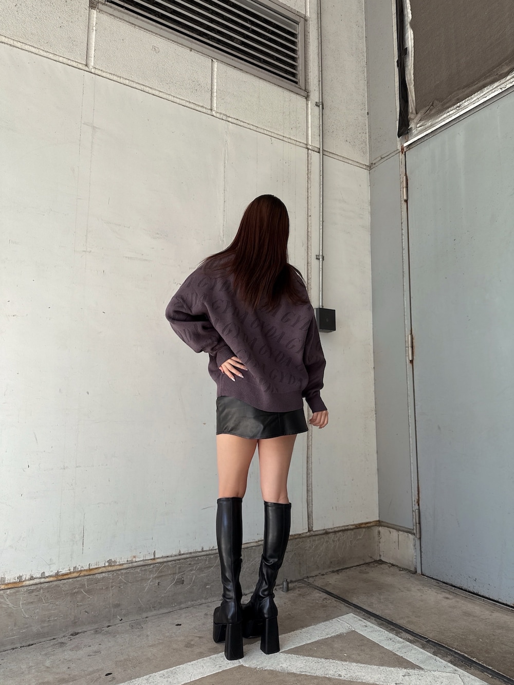 グレー系のニット/セーター、ブラック系のスカート、ブラック系のブーツを着用したレディースの秋コーディネートの3枚目の写真