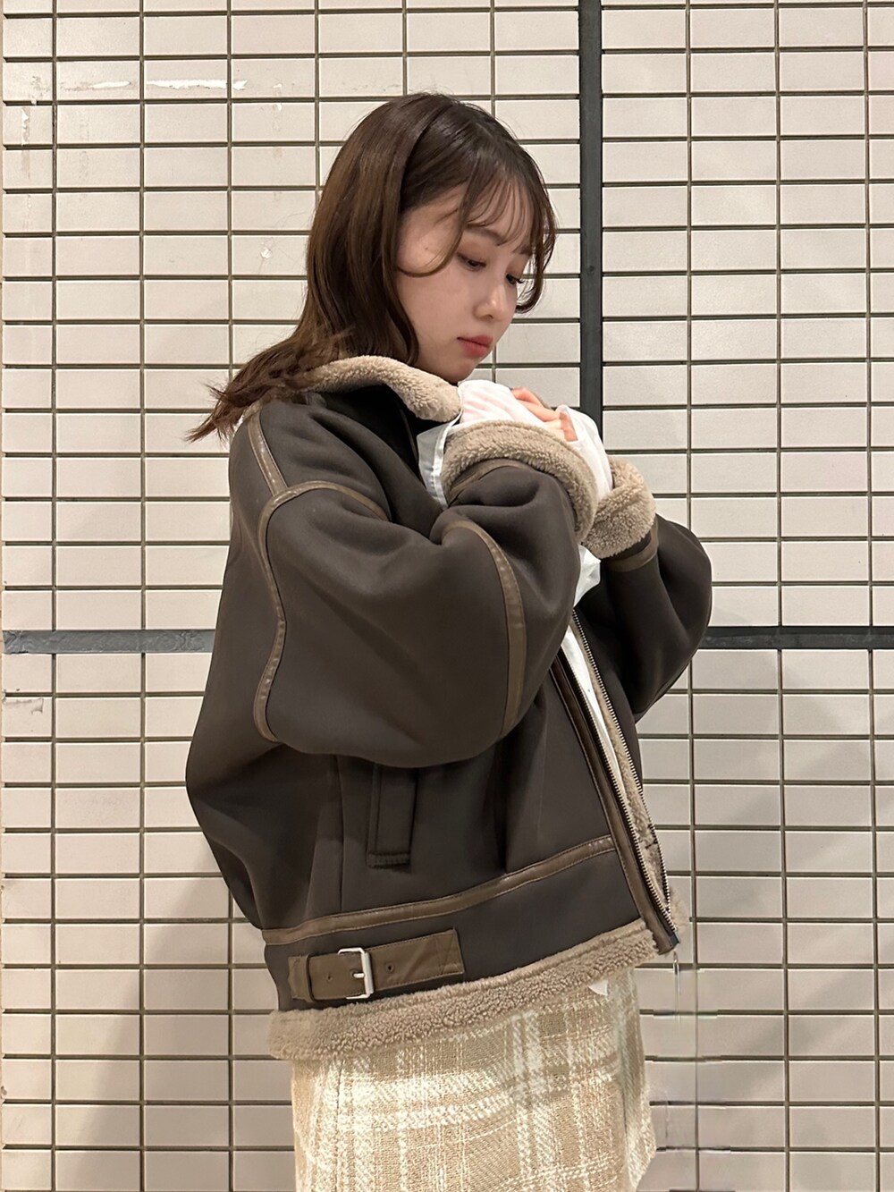 ブラウン系のブルゾン、ホワイト系のシャツ/ブラウス、ベージュ系のスカートを着用したレディースの秋コーディネートの3枚目の写真