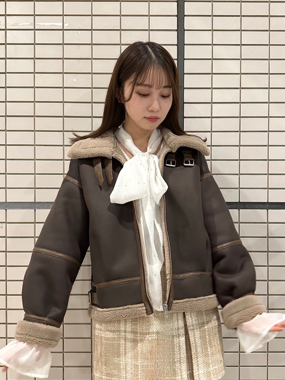 ブラウン系のブルゾン、ホワイト系のシャツ/ブラウス、ベージュ系のスカートを着用したレディースの秋コーディネートの4枚目の写真