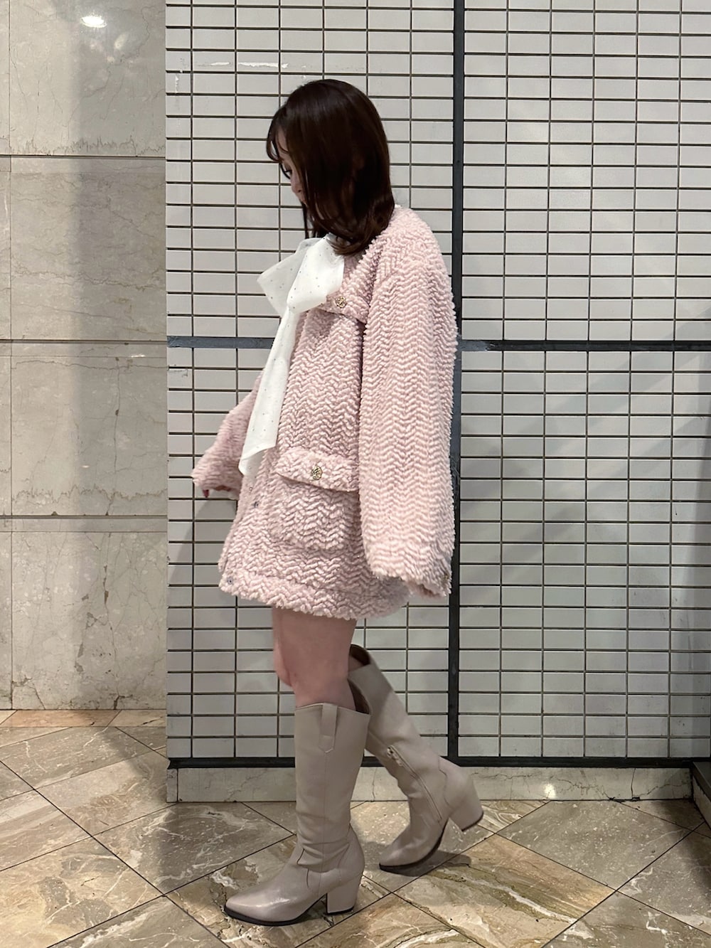 ピンク系のブルゾン、ホワイト系のシャツ/ブラウス、ベージュ系のスカートを着用したレディースの冬コーディネートの2枚目の写真