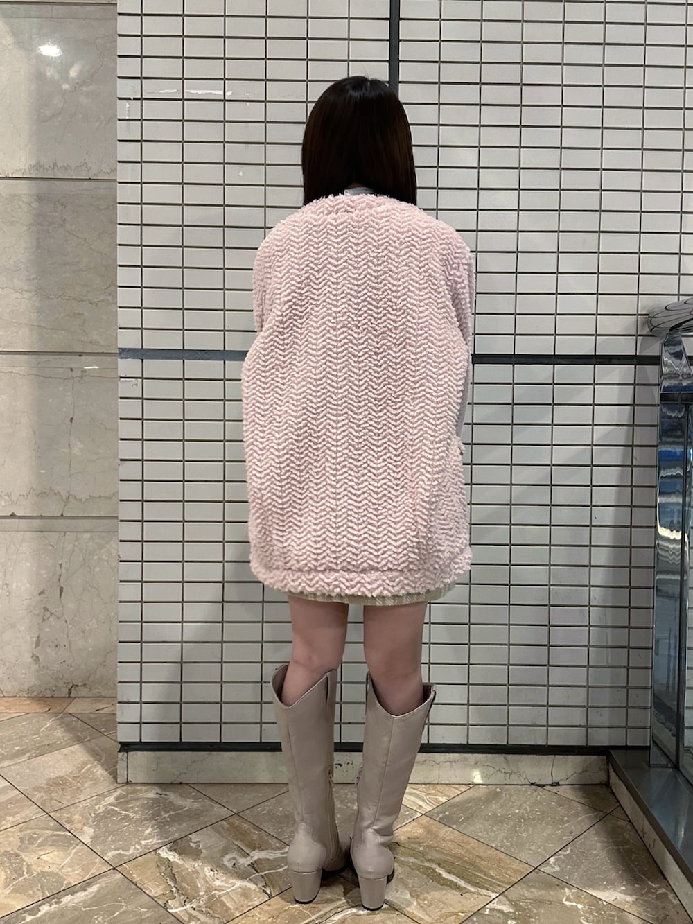 ピンク系のブルゾン、ホワイト系のシャツ/ブラウス、ベージュ系のスカートを着用したレディースの冬コーディネートの3枚目の写真