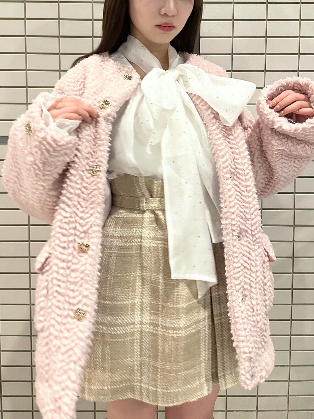 ピンク系のブルゾン、ホワイト系のシャツ/ブラウス、ベージュ系のスカートを着用したレディースの冬コーディネートの4枚目の写真