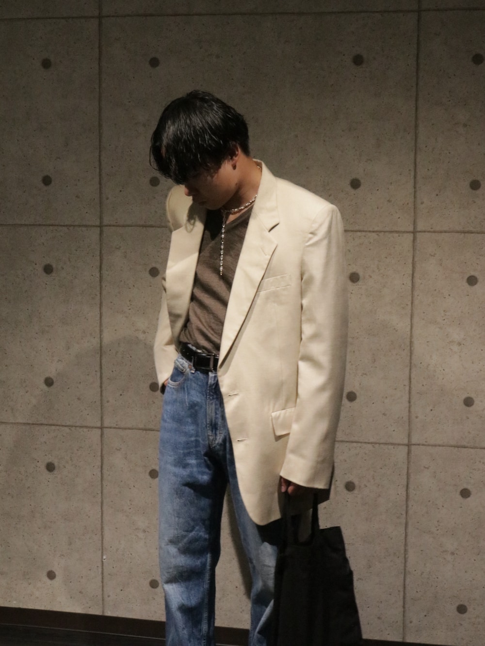 ブルー系のデニムパンツ、ブラウン系のローファー、ベージュ系のジャケット/アウターを着用したメンズの秋コーディネートの2枚目の写真