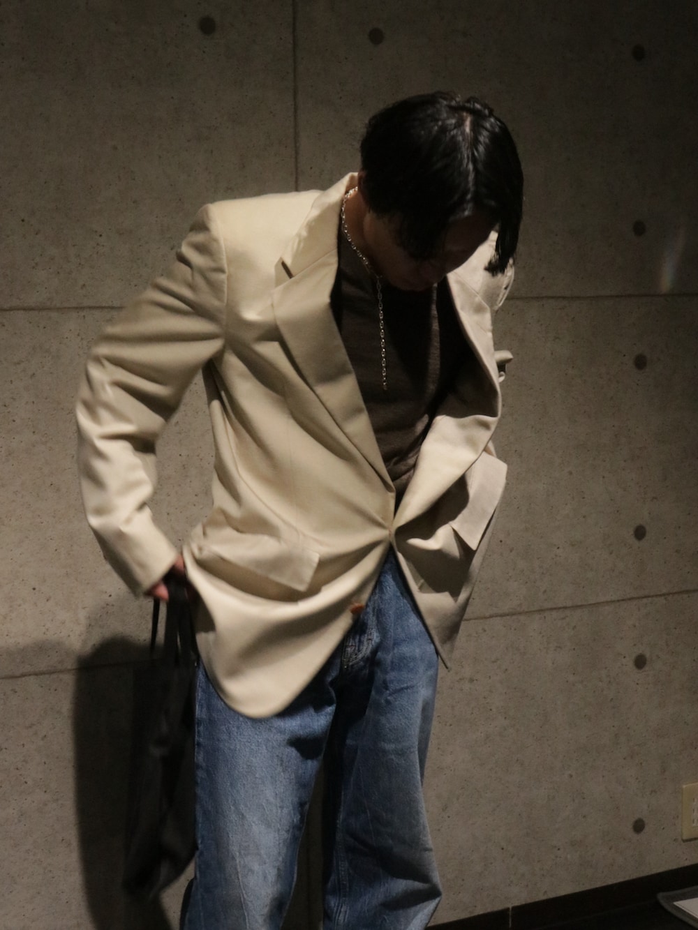 ブルー系のデニムパンツ、ブラウン系のローファー、ベージュ系のジャケット/アウターを着用したメンズの秋コーディネートの5枚目の写真