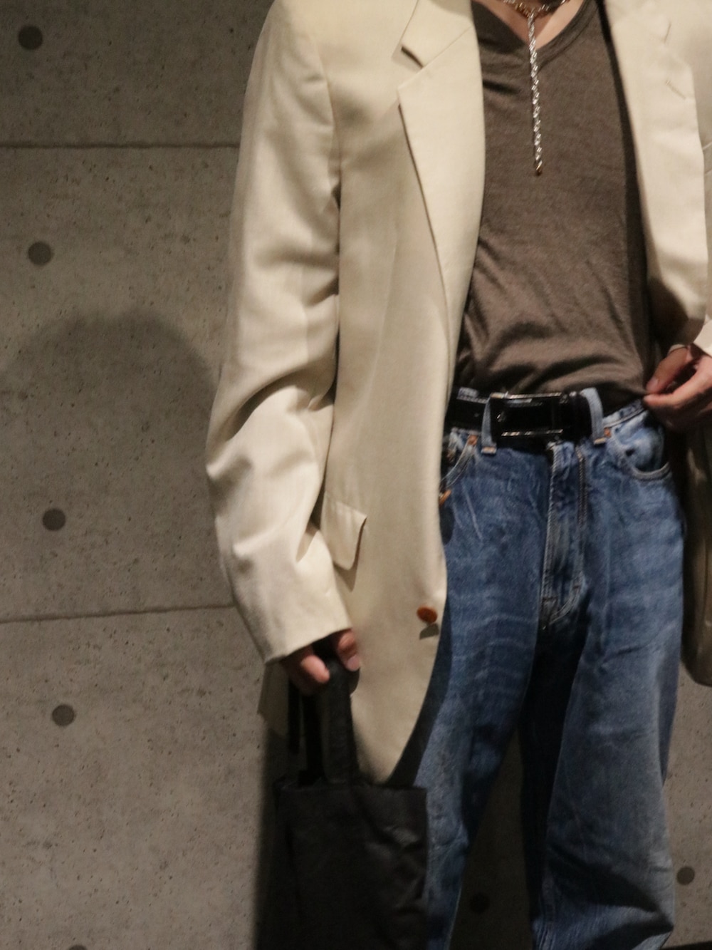 ブルー系のデニムパンツ、ブラウン系のローファー、ベージュ系のジャケット/アウターを着用したメンズの秋コーディネートの3枚目の写真