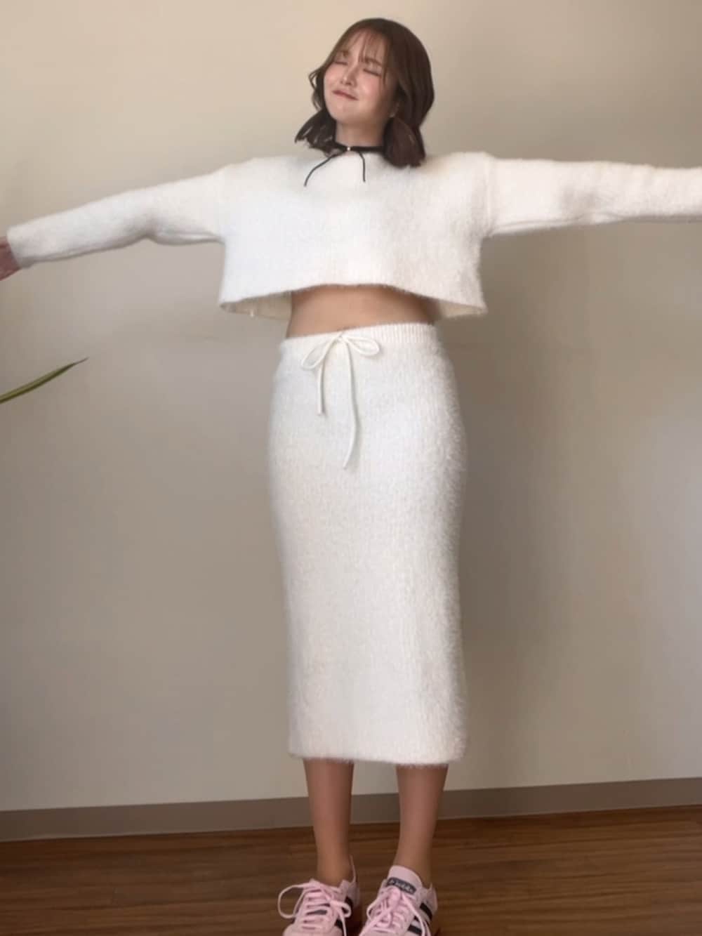 ホワイト系のニット/セーター、ピンク系のスニーカー、ブラック系のチョーカーを着用したレディースの春コーディネートの4枚目の写真