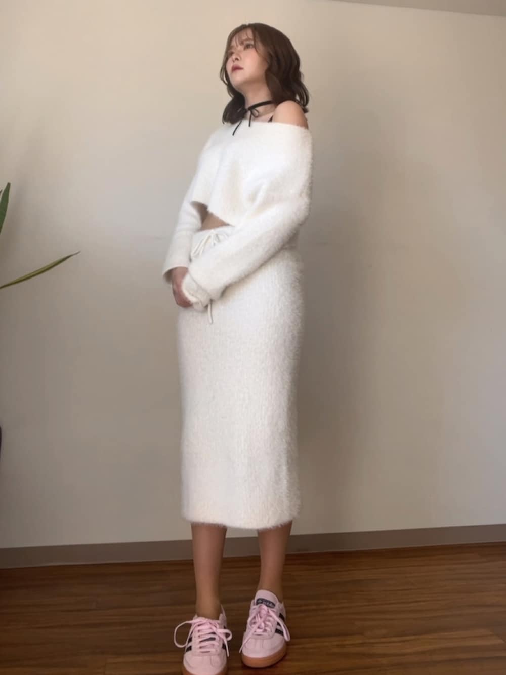 ホワイト系のニット/セーター、ピンク系のスニーカー、ブラック系のチョーカーを着用したレディースの春コーディネートの2枚目の写真