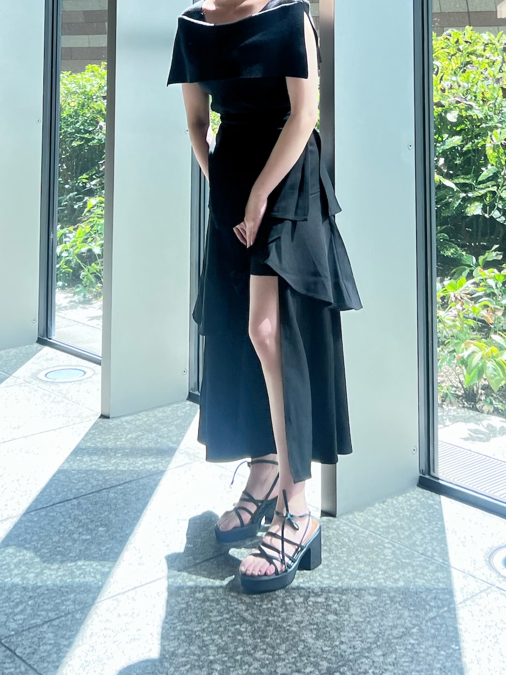 ブラック系のニット/セーター、ブラック系のスカート、ブラック系のサンダルを着用したレディースの夏コーディネートの3枚目の写真