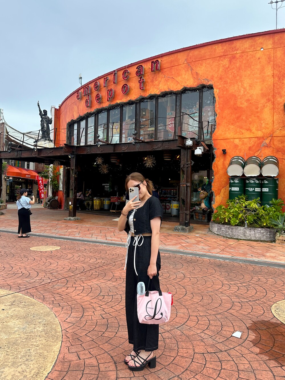 ブラック系のセットアップ、ブラック系のサンダルを着用したレディースの夏コーディネートの3枚目の写真