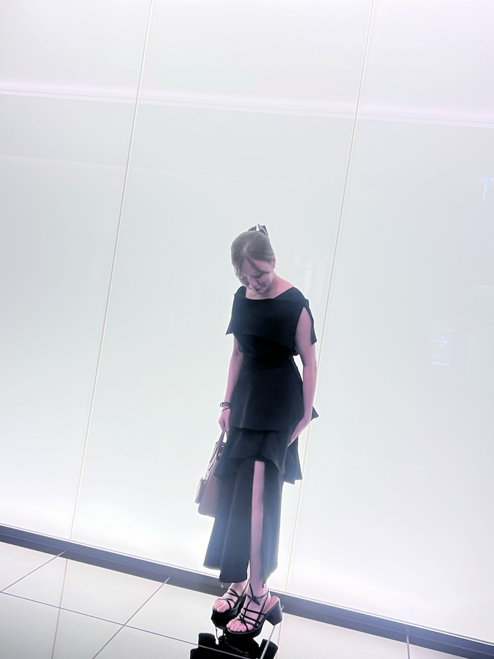 ブラック系のニット/セーター、ブラック系のスカート、ブラック系のサンダルを着用したレディースの夏コーディネートの2枚目の写真