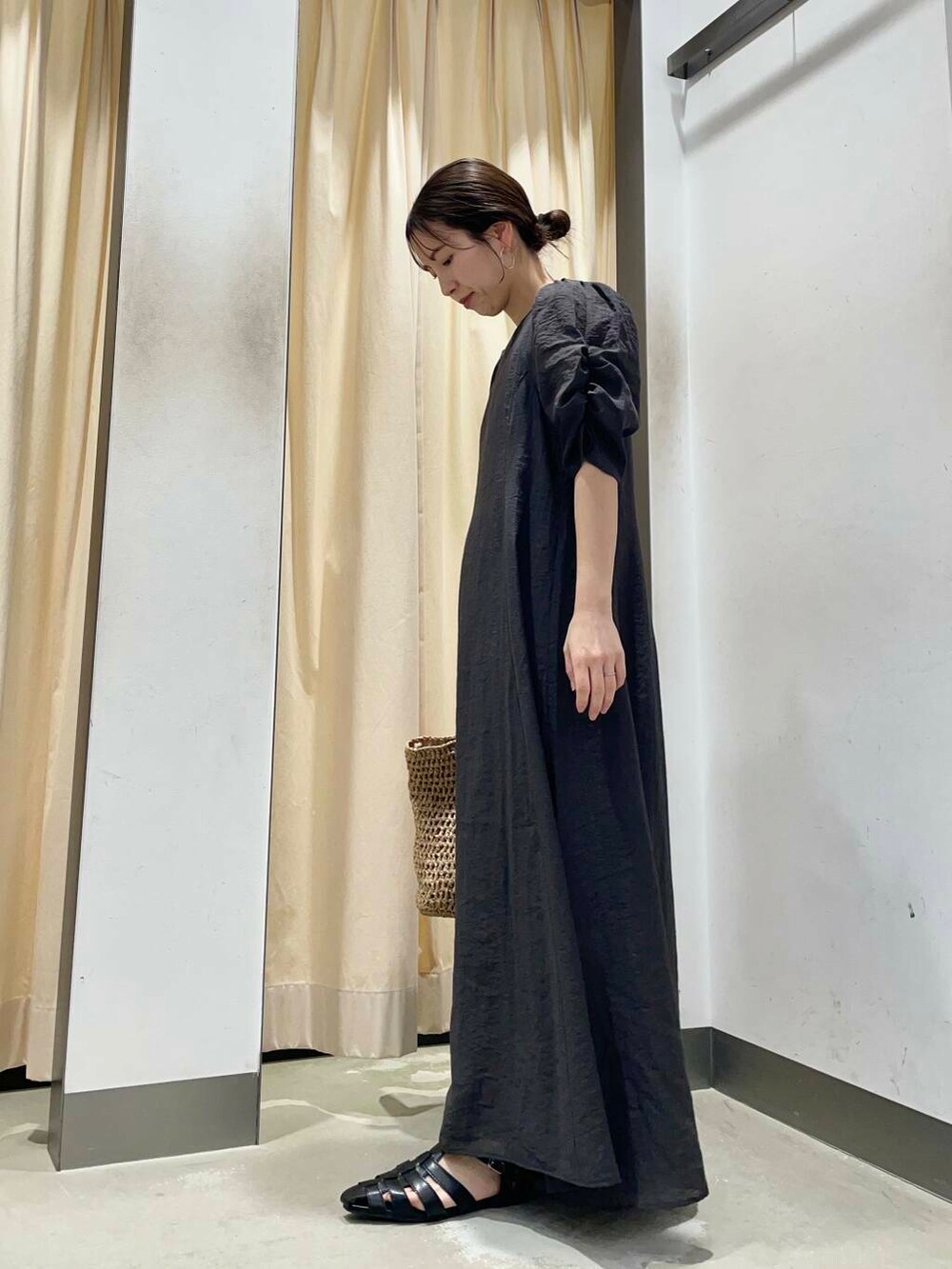 ベージュ系のトートバッグ、ブラック系のサンダルを着用したレディースの春コーディネートの2枚目の写真