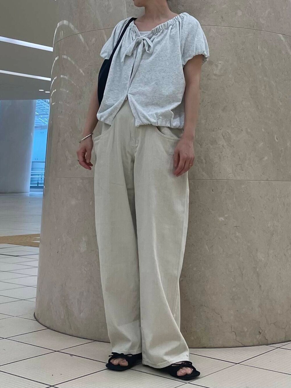 ブラック系のサンダル、ブラック系のショルダーバッグ、ベージュ系のスウェットを着用したレディースの夏コーディネートの3枚目の写真