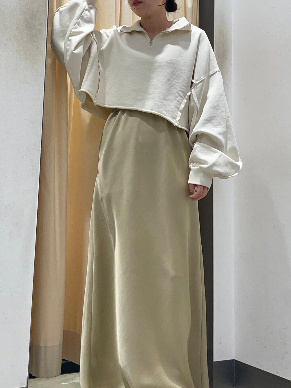 ホワイト系のスウェット、ベージュ系のスカート、ブラウン系のキャップを着用したレディースの冬コーディネートの3枚目の写真