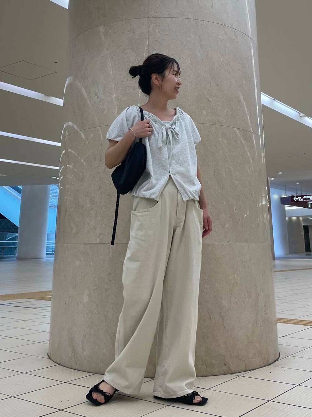 ブラック系のサンダル、ブラック系のショルダーバッグ、ベージュ系のスウェットを着用したレディースの夏コーディネートの2枚目の写真