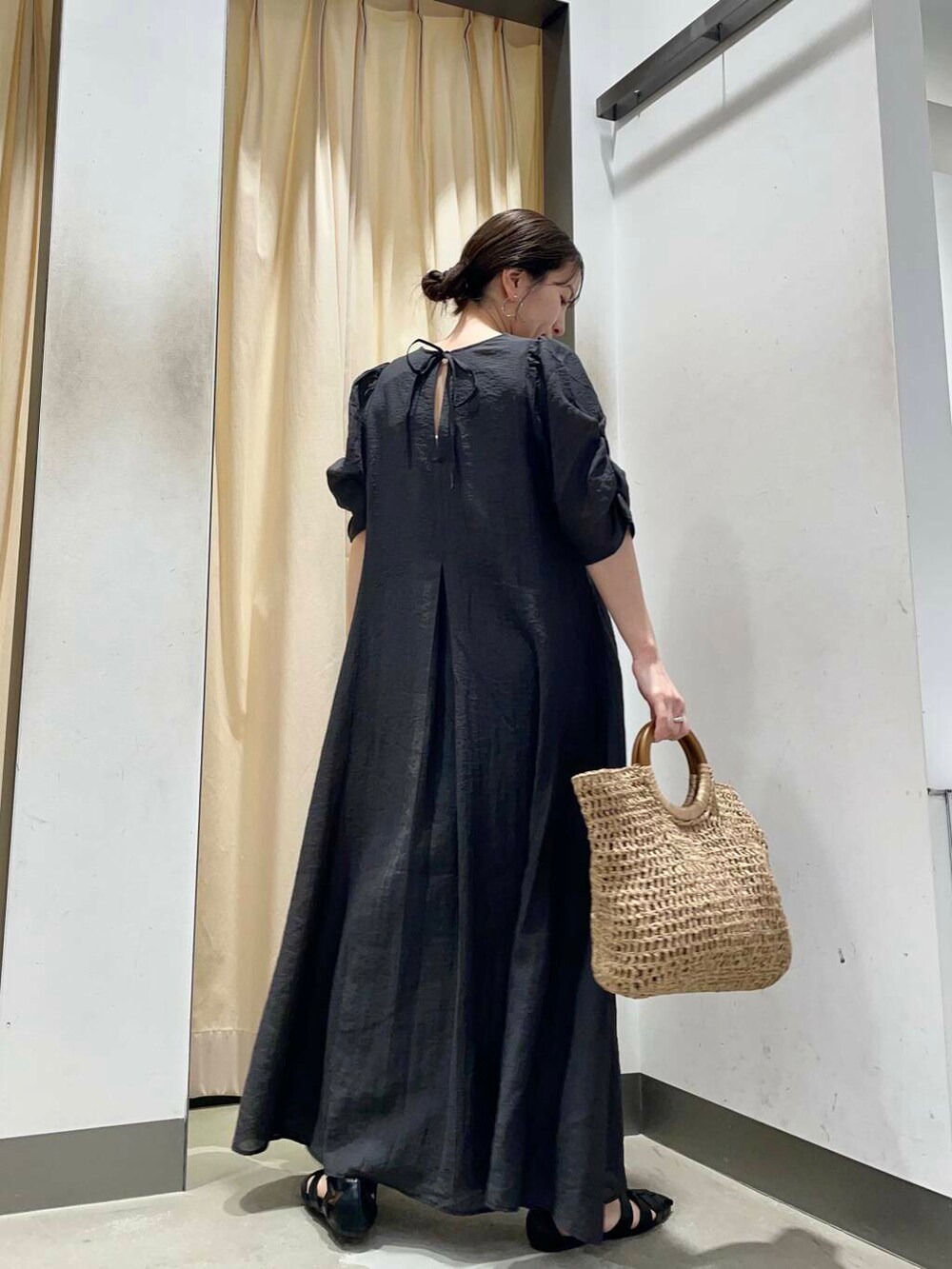 ベージュ系のトートバッグ、ブラック系のサンダルを着用したレディースの春コーディネートの3枚目の写真