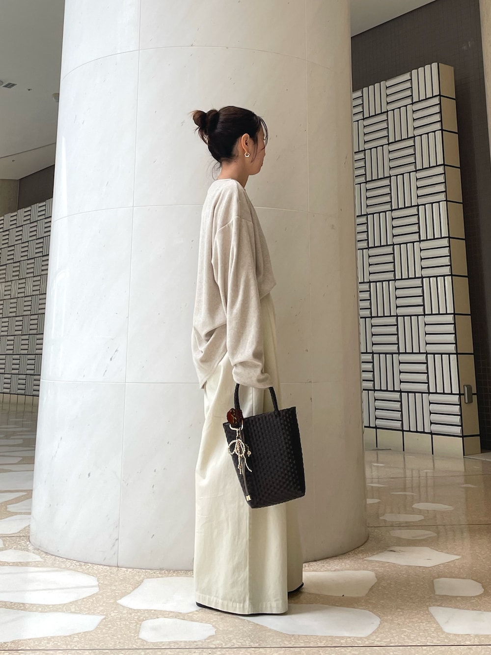 ベージュ系のTシャツ/カットソー、ホワイト系のその他パンツ、ブラウン系のトートバッグを着用したレディースの春コーディネートの2枚目の写真