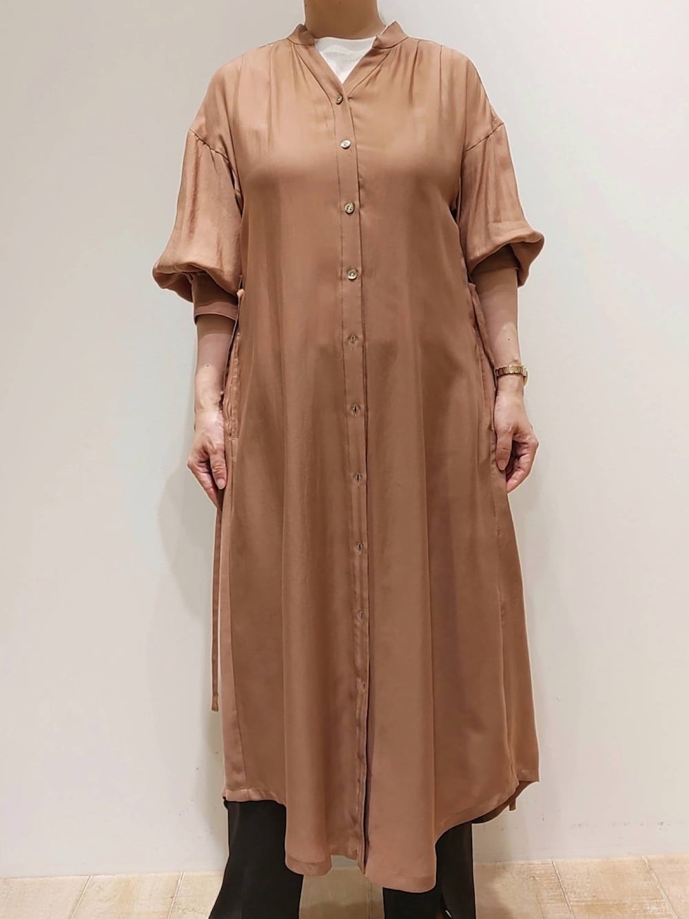 イエロー系のワンピース、ホワイト系のTシャツ/カットソー、ブラック系のスラックスを着用したレディースの春コーディネートの2枚目の写真