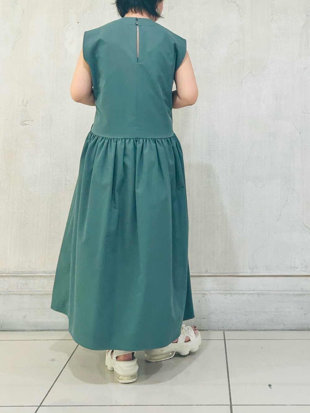 グリーン系のワンピースを着用したレディースの夏コーディネートの2枚目の写真