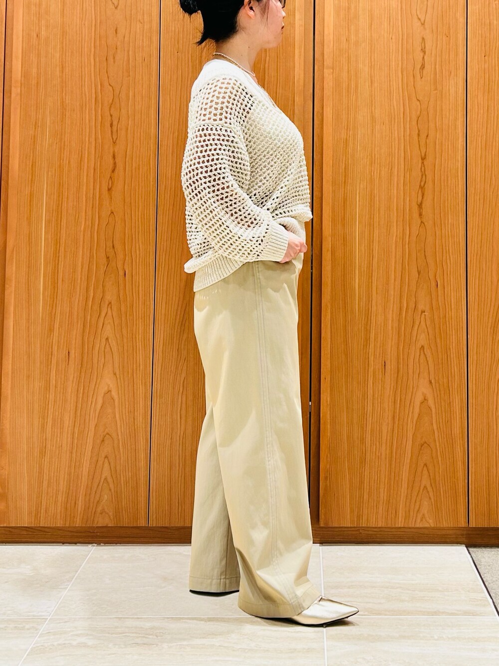 ベージュ系のその他パンツ、ホワイト系のタンクトップ、ベージュ系のニット/セーターを着用したレディースの春コーディネートの2枚目の写真