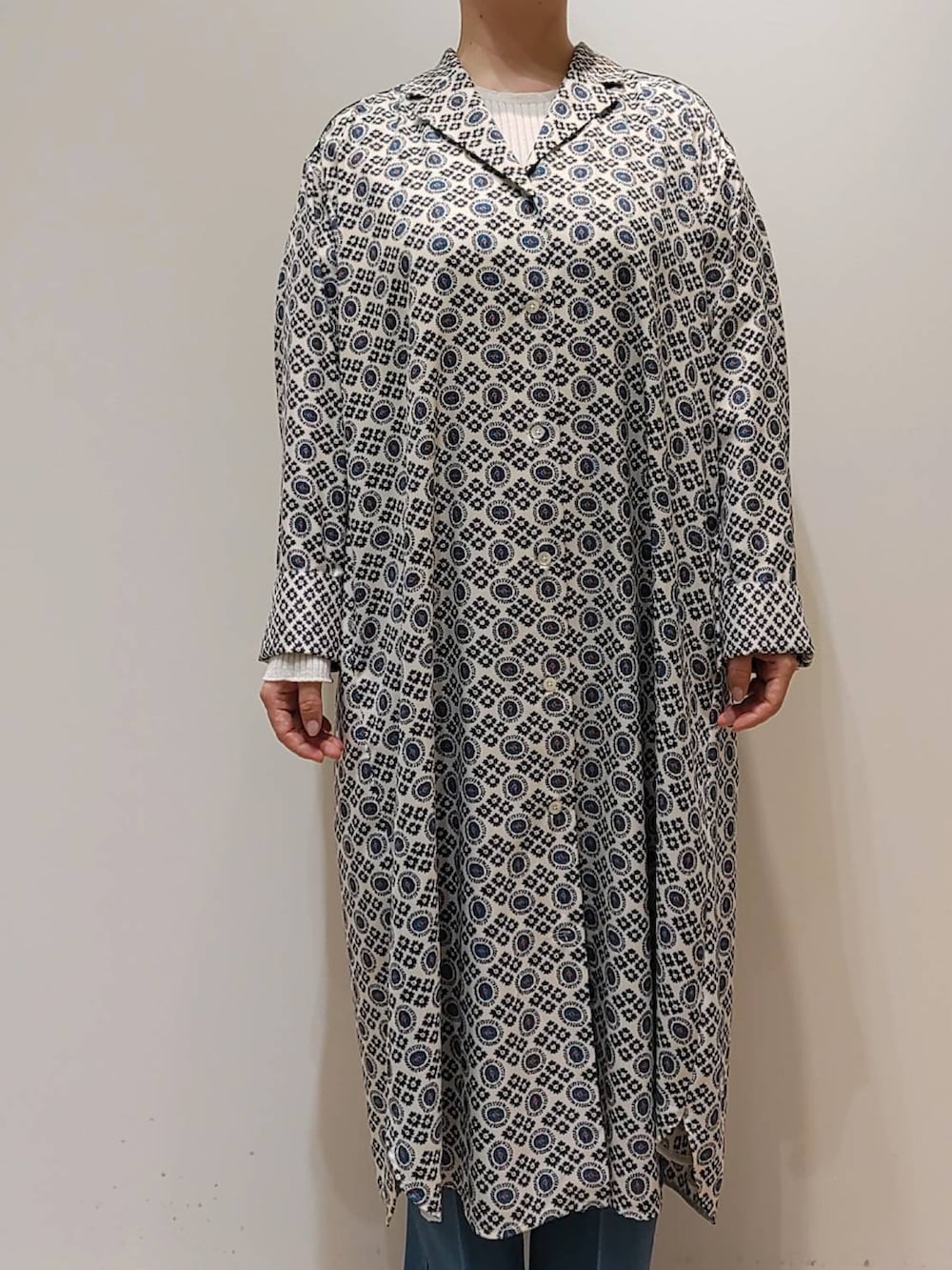 ブルー系のワンピース、ブルー系のデニムパンツ、ホワイト系のニット/セーターを着用したレディースの冬コーディネートの2枚目の写真