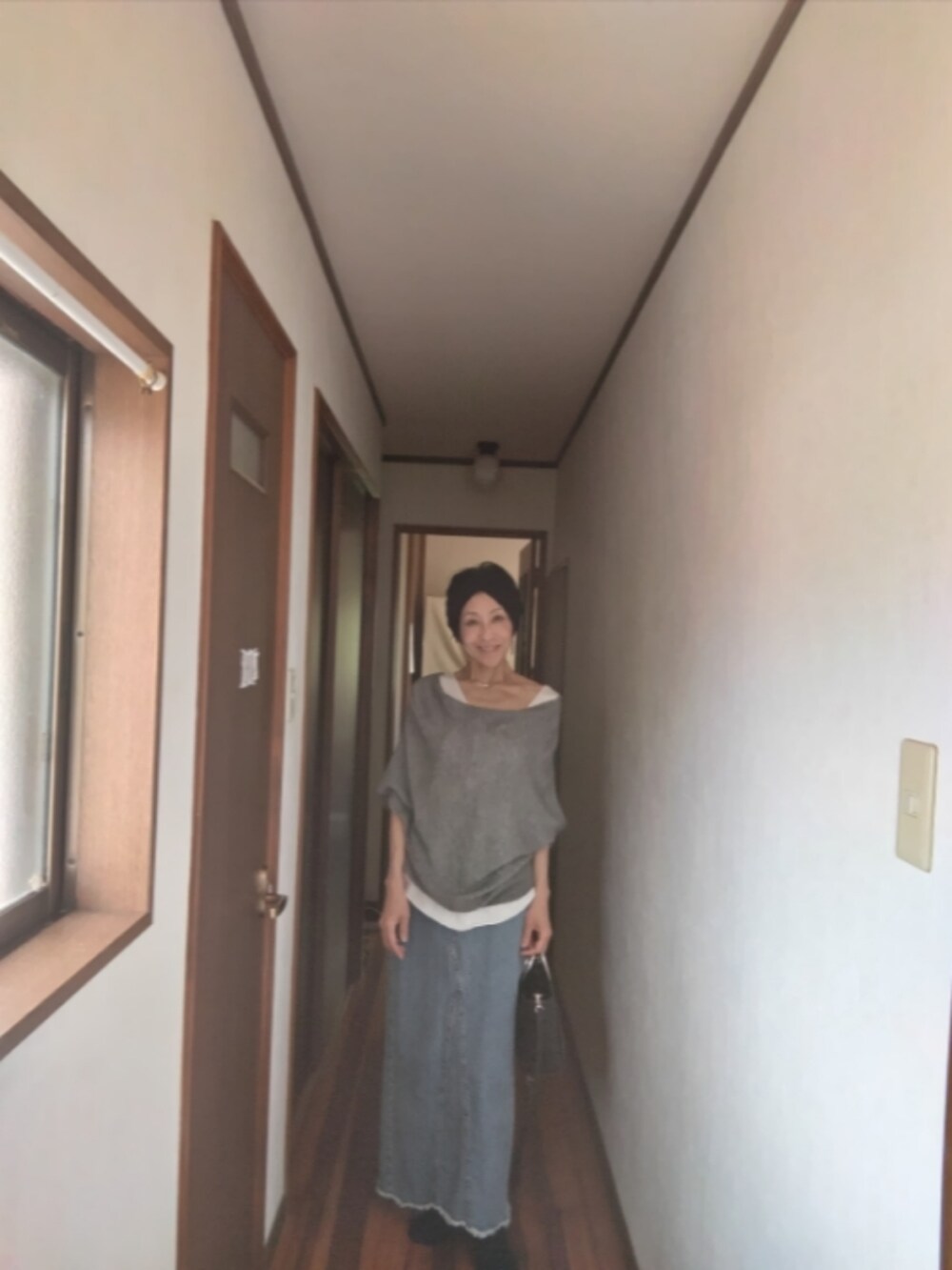 グレー系のデニムスカートを着用したレディースの春コーディネートの2枚目の写真