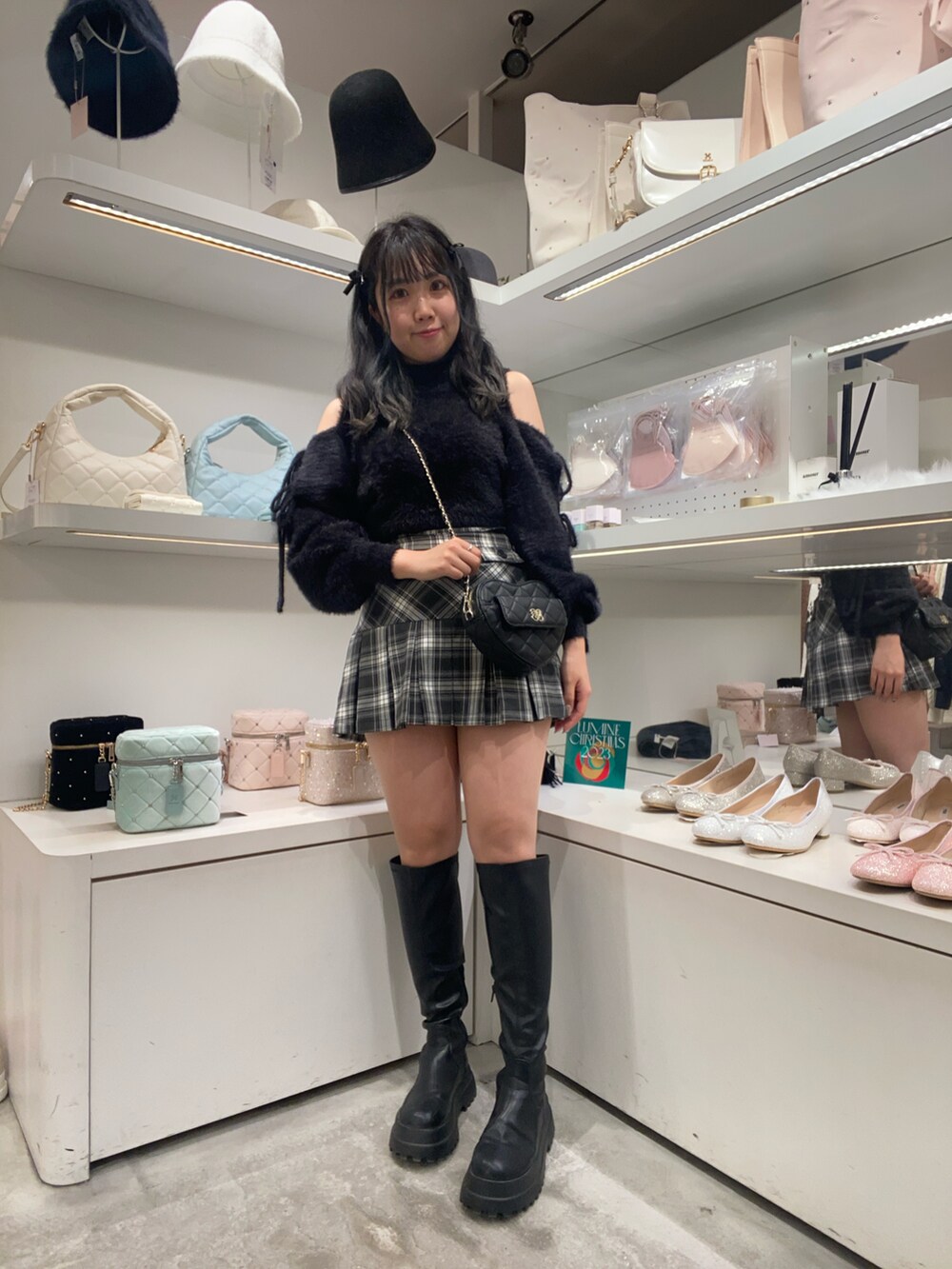 ブラック系のニット/セーター、ブラック系のショルダーバッグ、ブラック系のブーツを着用したレディースの冬コーディネートの2枚目の写真