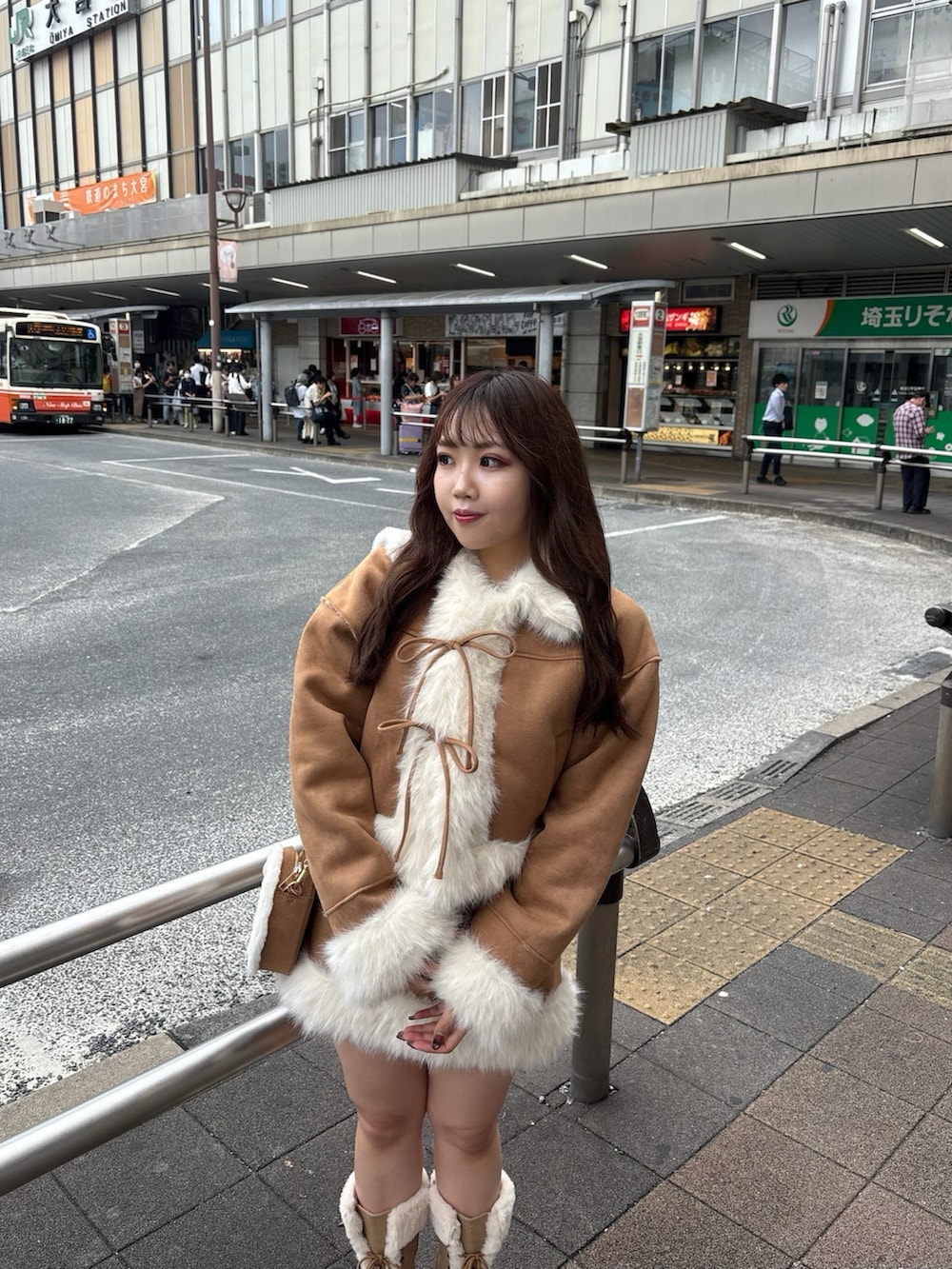 ベージュ系のブーツ、ベージュ系のショルダーバッグ、イエロー系のスカートを着用したレディースの秋コーディネートの2枚目の写真