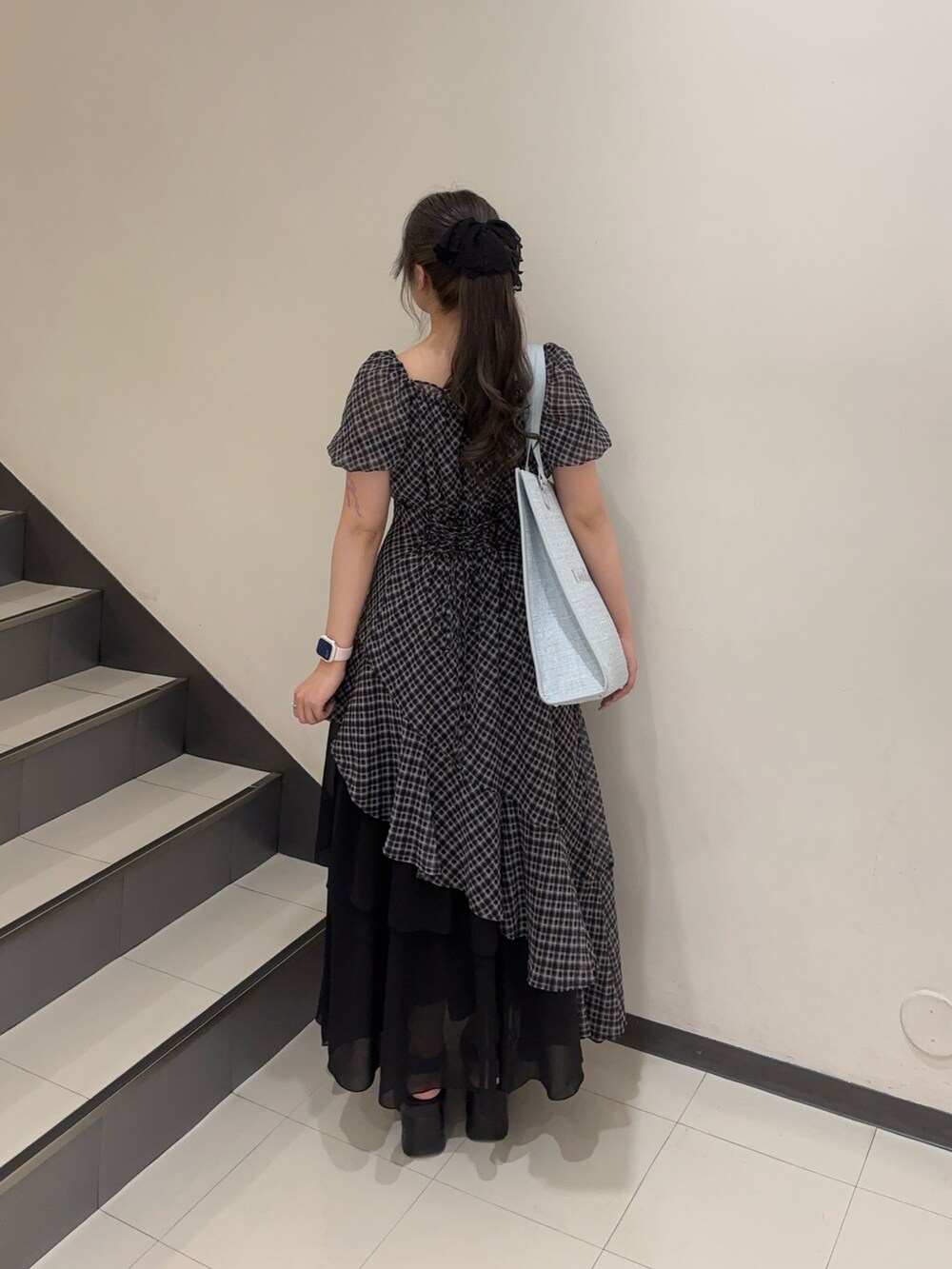 ブルー系のトートバッグ、ブラック系のサンダル、その他のワンピースを着用したレディースの夏コーディネートの2枚目の写真