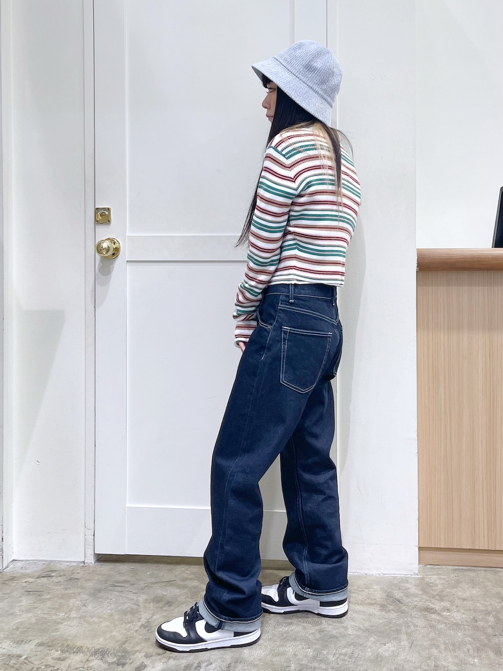 ホワイト系のカーディガン/ボレロ、ホワイト系のニット/セーター、ブルー系のデニムパンツを着用したレディースの秋コーディネートの2枚目の写真