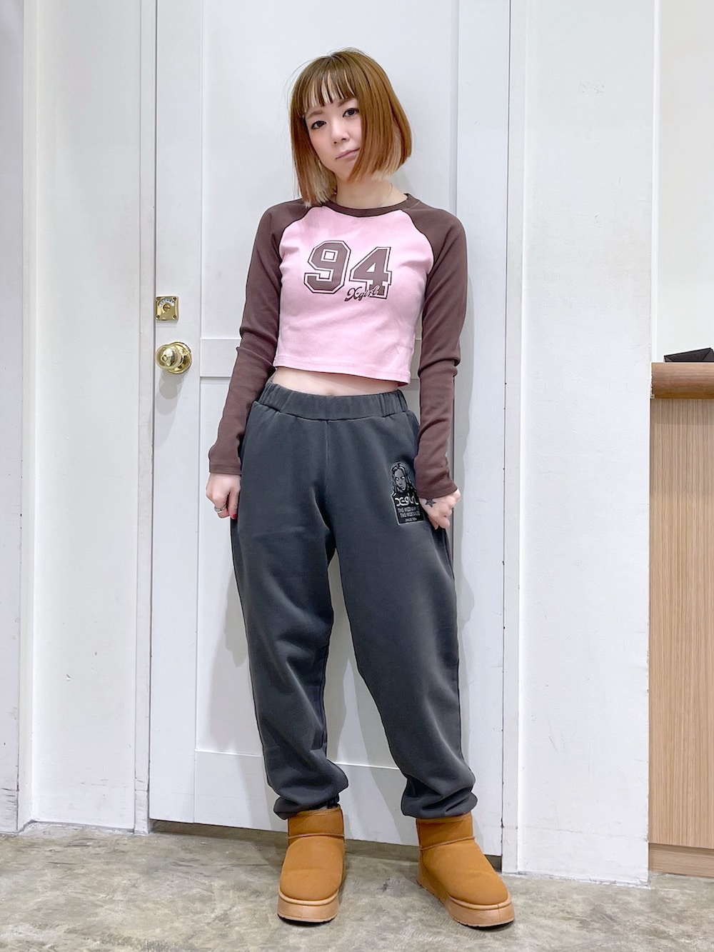 ブラック系のパーカー、ブラック系のスウェットパンツ、ピンク系のTシャツ/カットソーを着用したレディースの冬コーディネートの5枚目の写真