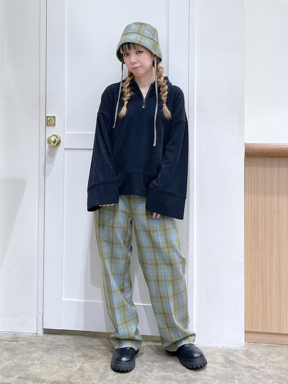 ブラック系のスウェット、グリーン系のその他パンツ、グリーン系のハットを着用したレディースの冬コーディネートの3枚目の写真