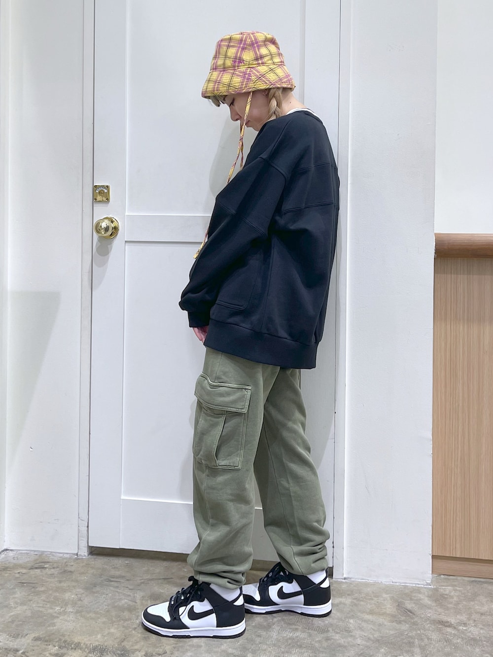 ブラック系のカーディガン/ボレロ、ホワイト系のTシャツ/カットソー、グリーン系のスウェットパンツを着用したレディースの冬コーディネートの3枚目の写真