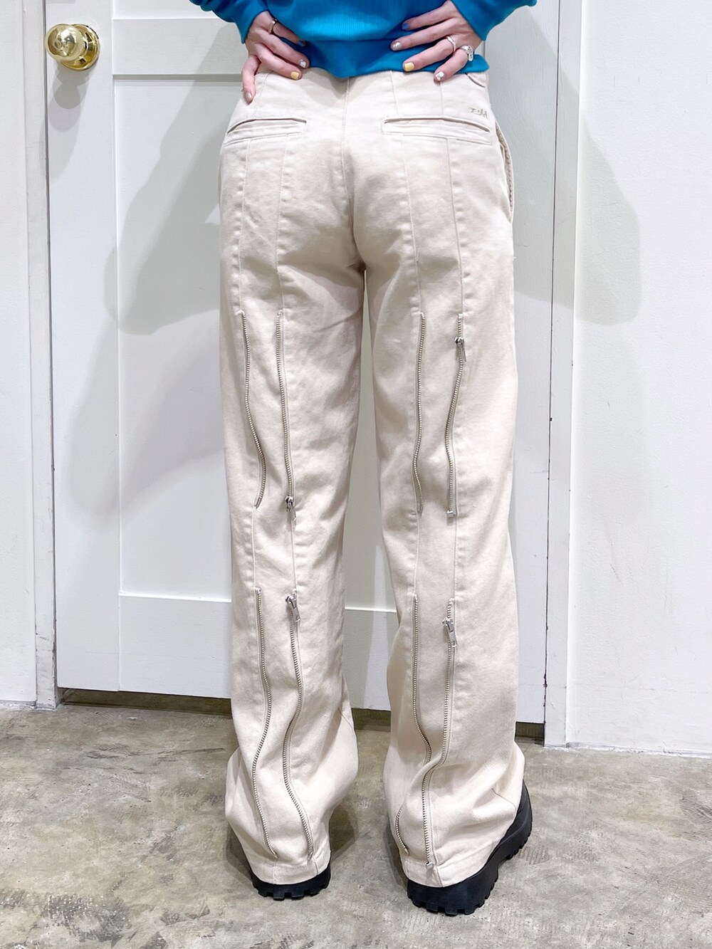 ブルー系のカーディガン/ボレロ、グレー系のTシャツ/カットソー、ベージュ系のデニムパンツを着用したレディースの春コーディネートの5枚目の写真