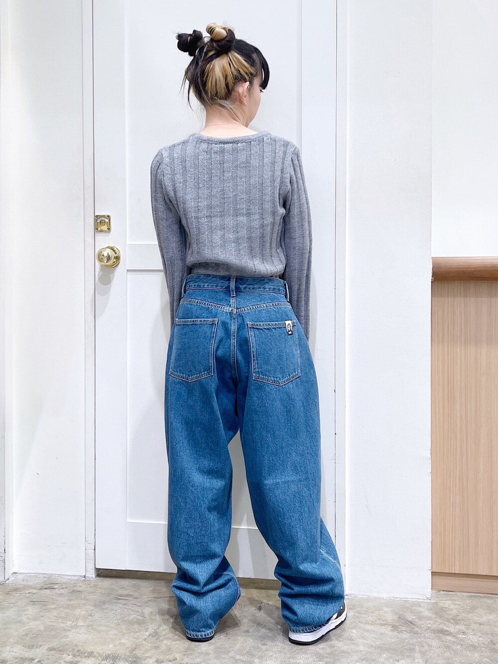 ブルー系のダウンジャケット/コート、グレー系のニット/セーター、ブルー系のデニムパンツを着用したレディースの秋コーディネートの8枚目の写真