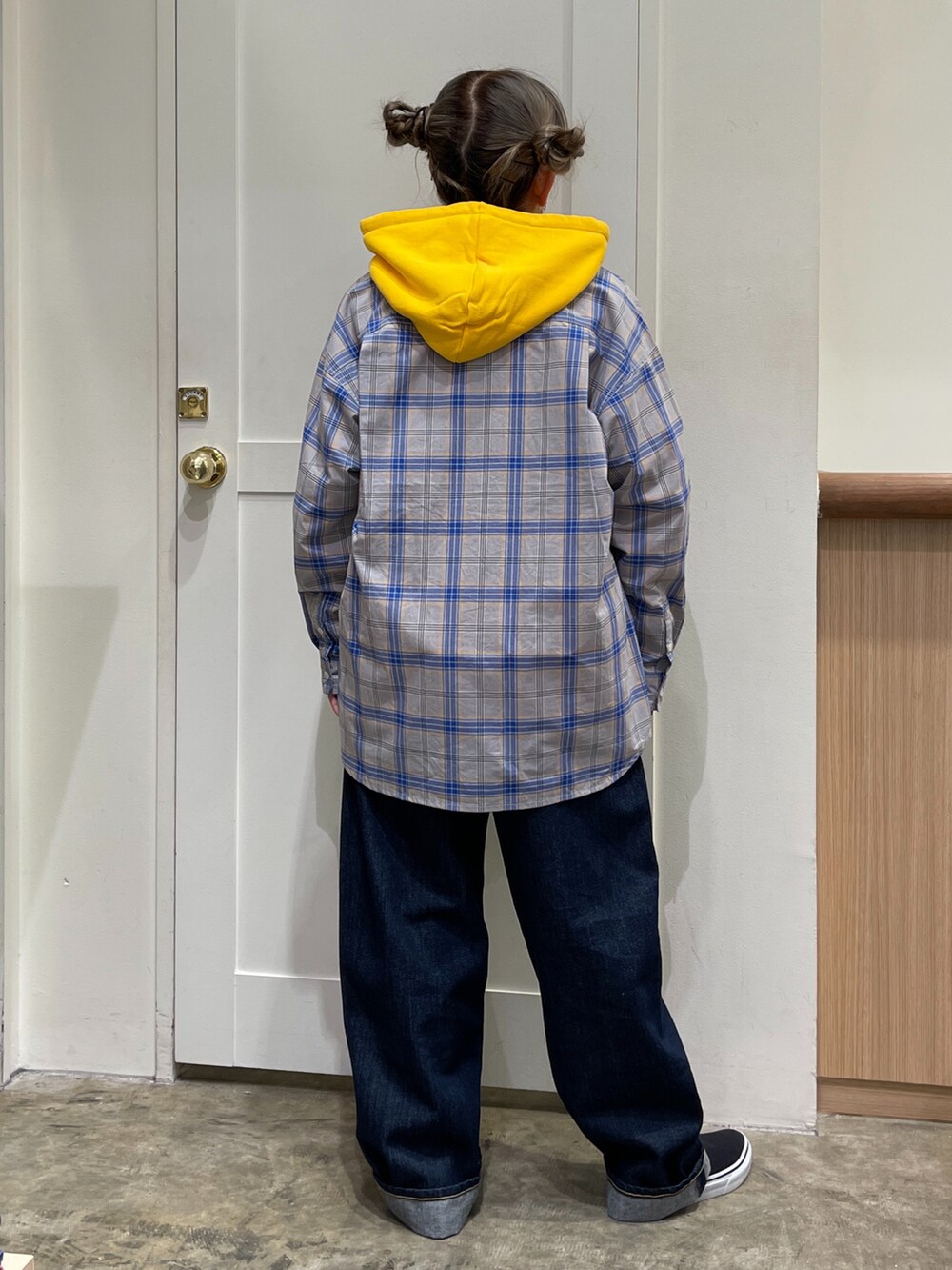 グレー系のシャツ/ブラウス、イエロー系のパーカー、ブルー系のデニムパンツを着用したレディースの秋コーディネートの4枚目の写真