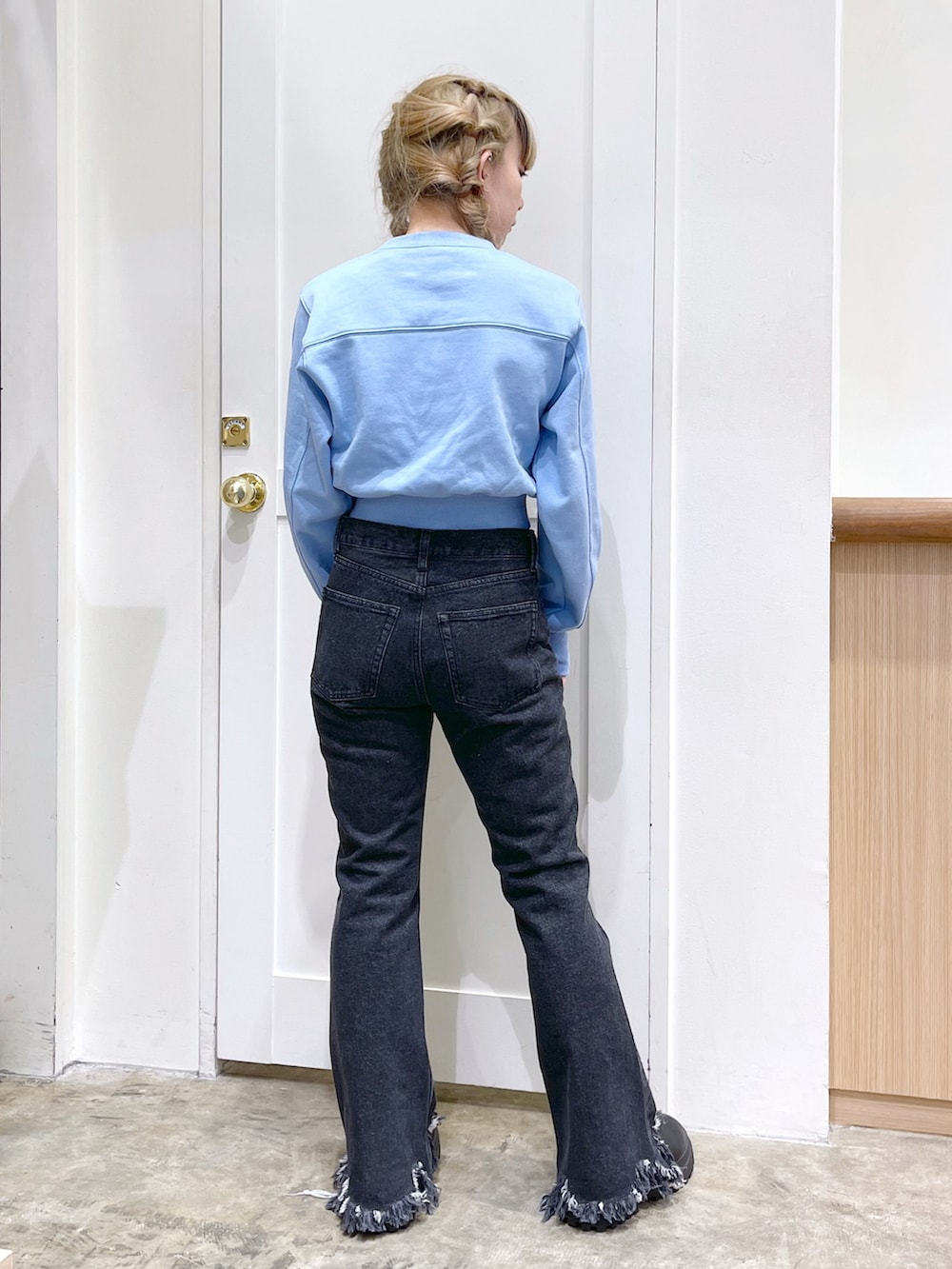 ブルー系のスウェット、ブラック系のデニムパンツ、ブラック系の財布を着用したレディースの冬コーディネートの5枚目の写真