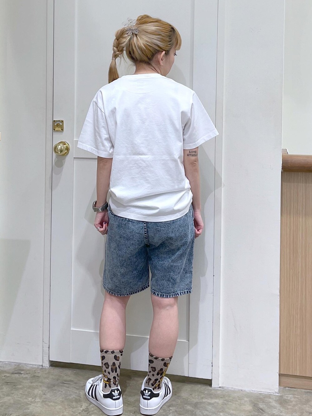 ホワイト系のTシャツ/カットソー、ブルー系のデニムパンツ、ベージュ系のソックス/靴下を着用したレディースの夏コーディネートの3枚目の写真