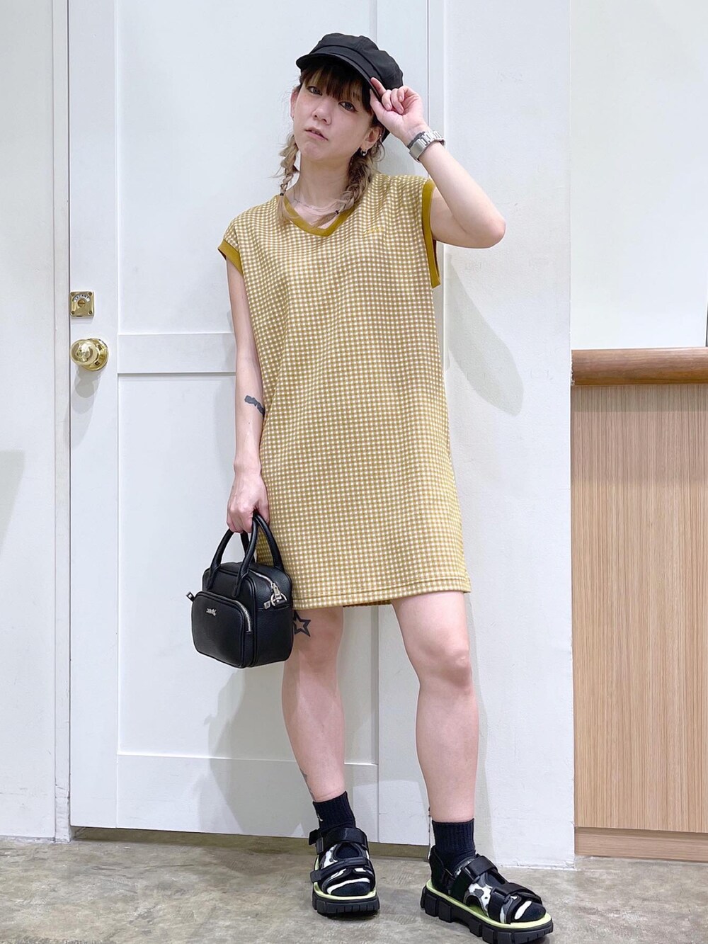 ベージュ系のワンピース、ブラック系のショルダーバッグ、ブラック系のサンダルを着用したレディースの夏コーディネートの3枚目の写真