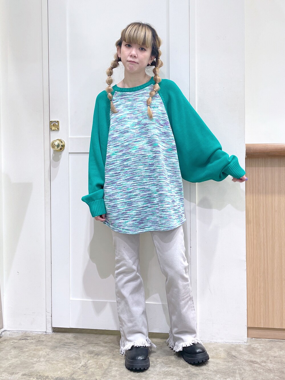 グリーン系のニット/セーター、ベージュ系のデニムパンツ、ブラック系のマフラーを着用したレディースの冬コーディネートの3枚目の写真