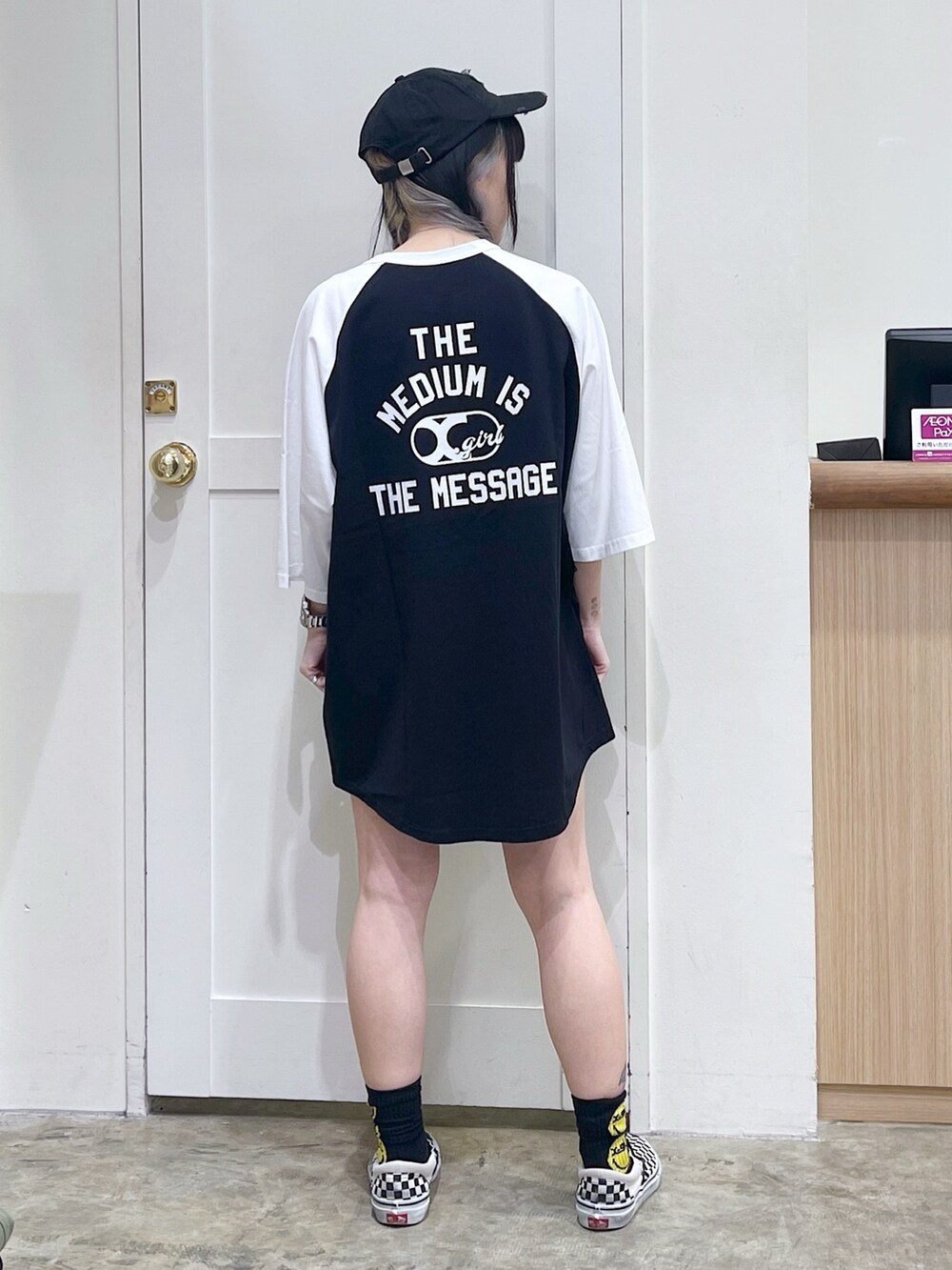 ブラック系のワンピース、その他のトートバッグ、グレー系のキャップを着用したレディースの夏コーディネートの4枚目の写真